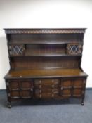 An oak dresser fitted cupboards and drawers beneath