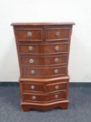A Georgian style serpentine fronted eight drawer chest together with a revolving book table