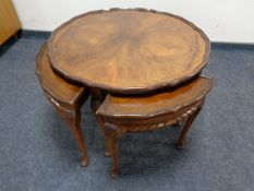 A circular walnut nest of five tables on pad feet