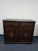 A double door cabinet fitted doors above in an oak finish
