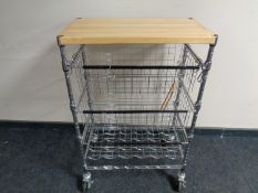 A pine topped metal three tier kitchen trolley with baskets