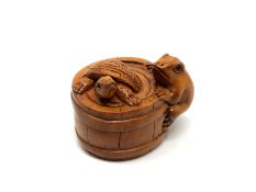A carved hardwood netsuke - Turtle and frog in barrel