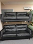 A pair of black leather two seater settees