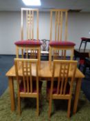An extending rubber wood kitchen table together with six high back chairs in a pine finish