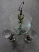 An ornate metal and glass two tier cake stand together with a further pair of metal candle holders