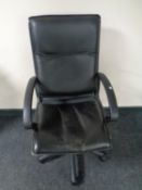 A faux leather swivel office armchair