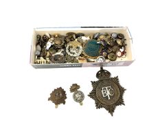 A box containing a quantity of military badges and buttons, British Transport Commission cap badge,