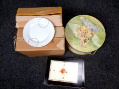 Two boxes containing ceramic dinner services together with a set of place mats and a Whinnie the