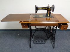 A 20th century Singer treadle sewing machine in oak table