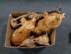 A box containing wooden animal ornaments to include giraffes, pigs,