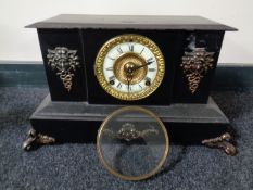 A 19th century cast iron mantel clock with brass and enamelled dial and metal mounts