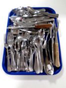 A tray containing a quantity of stainless steel cutlery