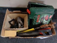 A box of vintage flat iron, hand saws,