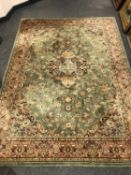 A machine made Persian carpet on green ground,