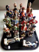 A tray containing seventeen china figures of soldiers in military dress
