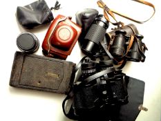 A box of assorted binoculars and cameras to include Carl Zeiss