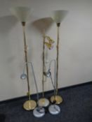 A pair of brass floor lamps with plastic shades together with three further floor lamps