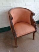 A reproduction carved mahogany tub elbow chair upholstered in a pink fabric