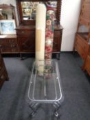 A contemporary metal glass topped coffee table together with two rolled woolen rugs
