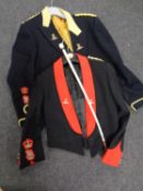 Two military formal dress tunics bearing badges together with a riding crop