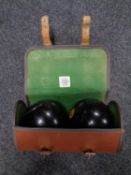 A pair of wooden lawn bowls in Spalding bag