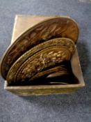 A brass embossed slipper box containing assorted brass plaques