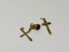Two antique crucifix pendants together with a further charm