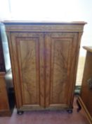 A 19th century continental burr walnut double door cabinet on bun feet