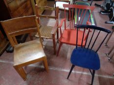 An antique painted kitchen rush seated armchair together with a further spindle back armchair and