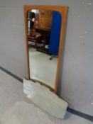 A 1970s teak framed mirror together with a frameless bevel edged mirror