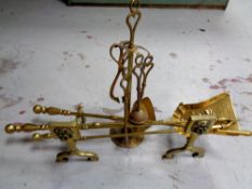 A pair of antique brass fire dogs together with three companion pieces,