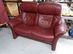 A Burgundy leather two seater reclining settee