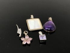 Four silver / white metal pendants