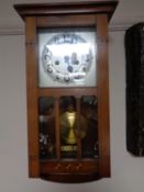 An Edwardian wall clock with silvered dial