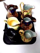 A tray containing an Era ware floral pattern jug together with five further antique jugs to include