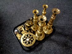 A tray of assorted brass ware to include antique brass candlestick, door handles, horse brasses,