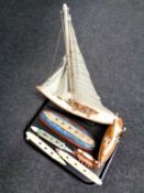 A tray containing two wooden models, yachts, together with five further models,