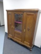A 20th century continental triple door sideboard with glazed central door