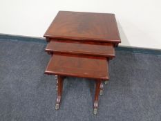 A nest of three Regency style tables on brass paw feet