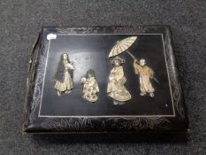 An antique Japanese black lacquered photo album with relief panel front