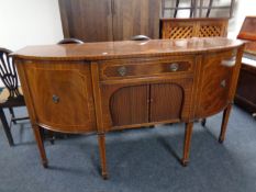 A Regency style shaped front inlaid mahogany sideboard on raised legs