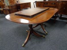 A Regency style twin pedestal extending dining table with two leaves