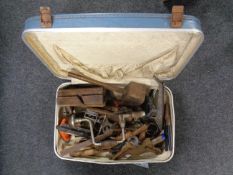 A suitcase containing a quantity of vintage hand working tools to include brace, planes, mallet,