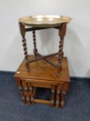 A brass topped table on folding barley twist stand together with a further nest of three tables