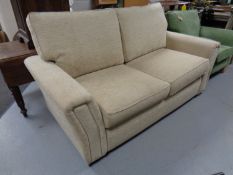 A Marks and Spencer settee upholstered in a beige fabric