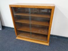 A walnut Art Deco bookcase with sliding glass doors