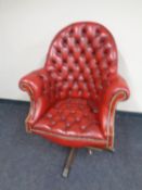A red button leather Chesterfield high backed swivel office armchair