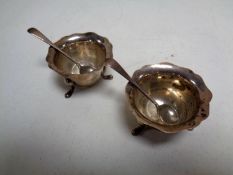 A pair of silver salts with spoons