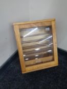 An oak wall mounted military collector's cabinet fitted a drawer