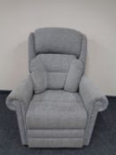 An electric reclining high backed armchair upholstered in a grey fabric